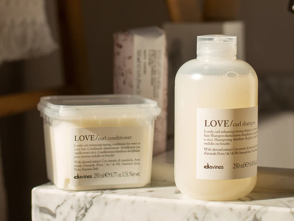 Davines shampoo and conditioner displayed in the sunlight.